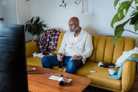 Spectateur devant un écran, télécommande à la main