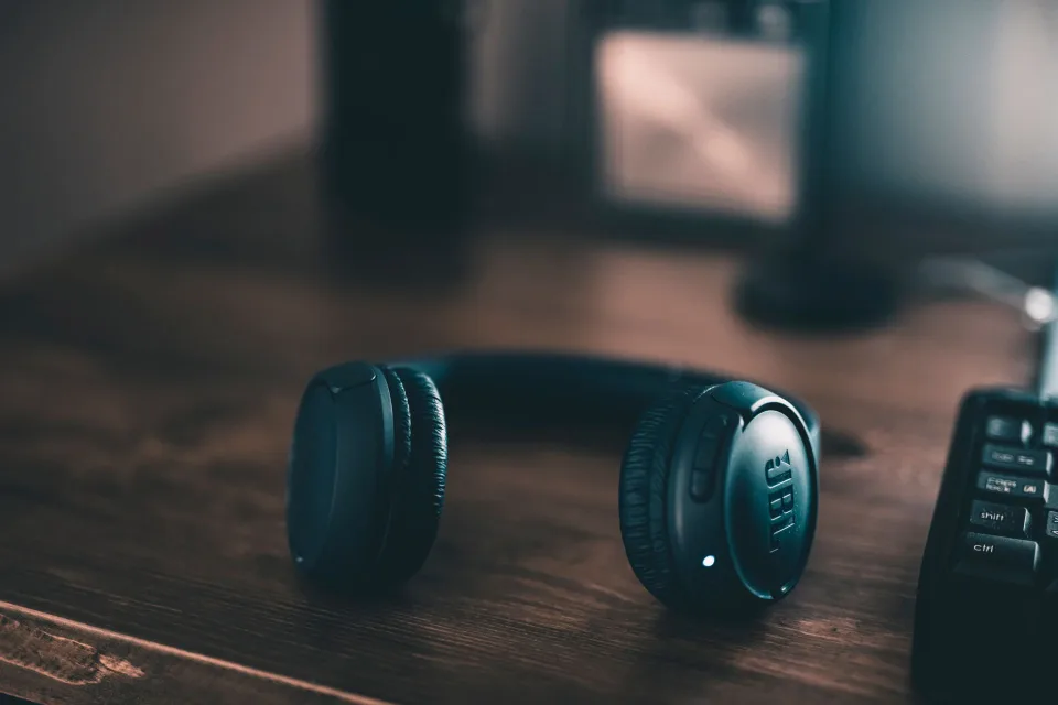 Casque audio posé près d’une paire d’enceintes